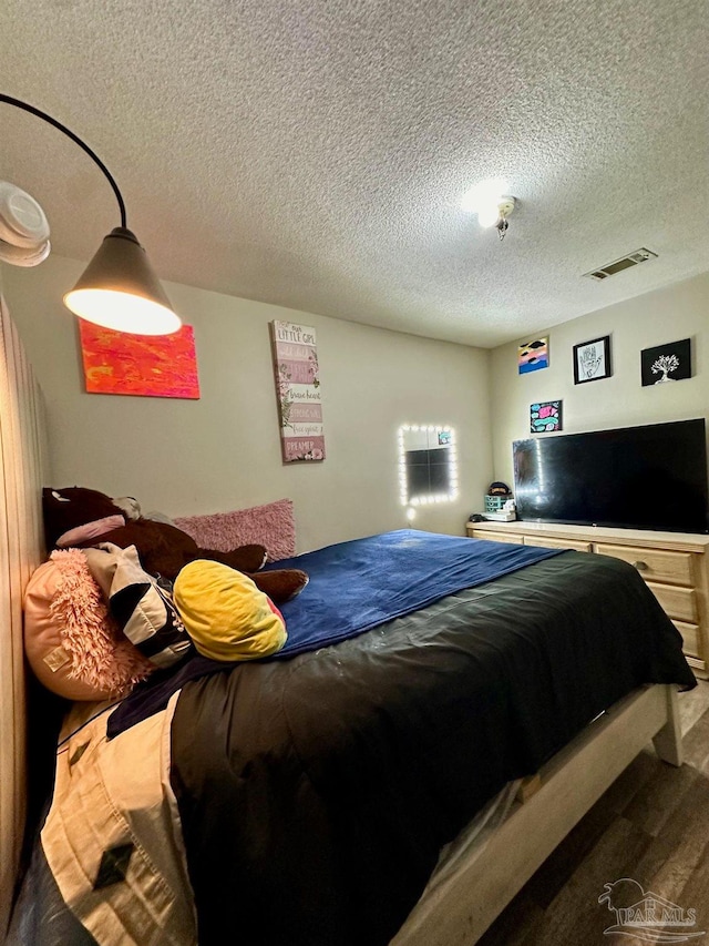 bedroom featuring a textured ceiling and hardwood / wood-style flooring