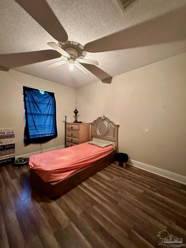 bedroom featuring dark hardwood / wood-style flooring, a textured ceiling, and ceiling fan