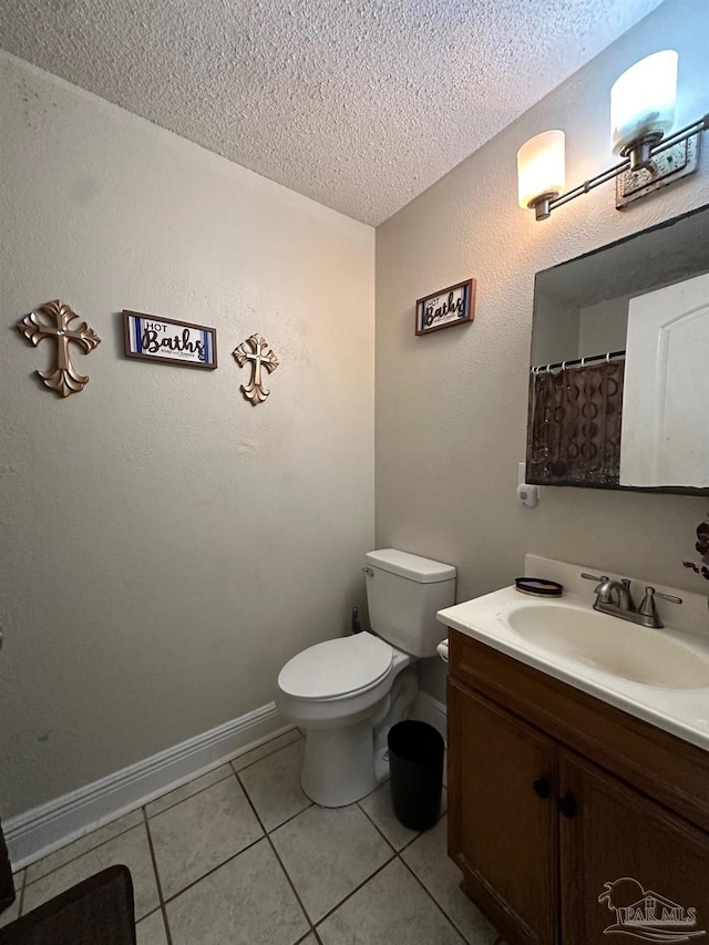 bathroom with vanity, toilet, a textured ceiling, and tile patterned flooring