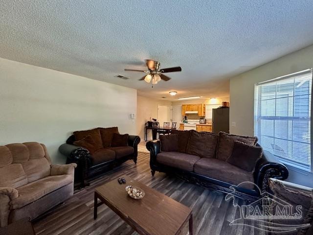 living room with hardwood / wood-style floors, a textured ceiling, and ceiling fan