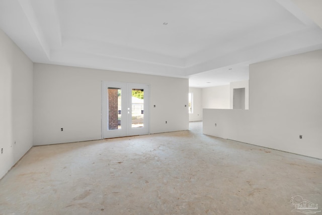 spare room featuring a tray ceiling and french doors