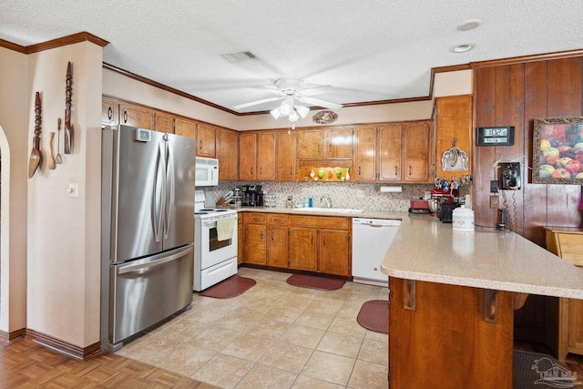 kitchen with white appliances, sink, crown molding, ceiling fan, and kitchen peninsula