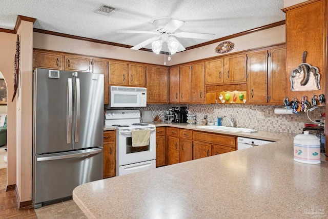 kitchen featuring a textured ceiling, sink, white appliances, and ornamental molding