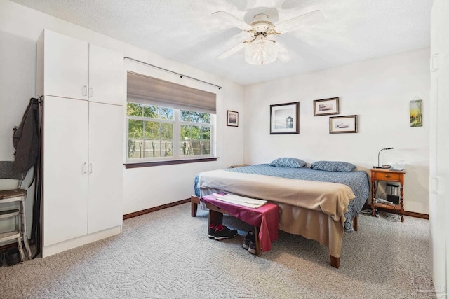 bedroom featuring carpet, ceiling fan, and a textured ceiling