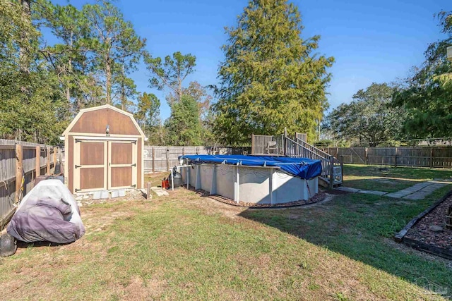 view of yard featuring a covered pool and a storage shed