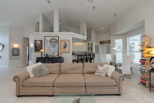 tiled living room featuring high vaulted ceiling