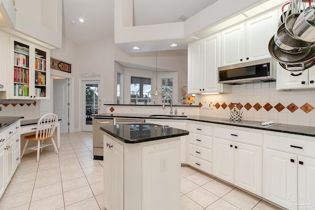 kitchen with pendant lighting, appliances with stainless steel finishes, sink, and white cabinets