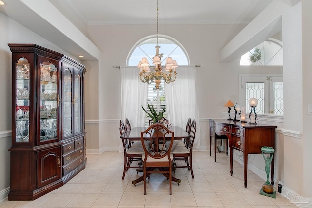 tiled dining area with ornamental molding and an inviting chandelier