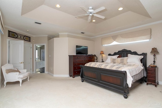 carpeted bedroom featuring ensuite bathroom, ornamental molding, ceiling fan, and a raised ceiling