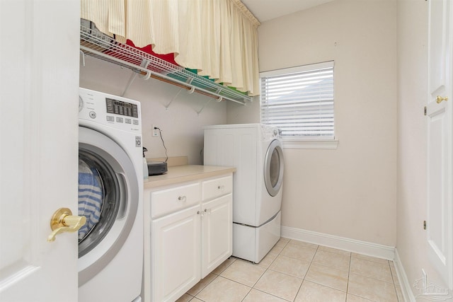 laundry room with cabinets, light tile patterned floors, and separate washer and dryer