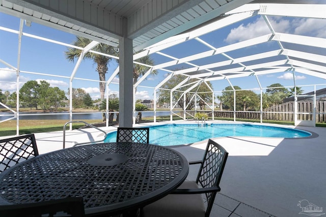 view of swimming pool featuring glass enclosure, a water view, and a patio area