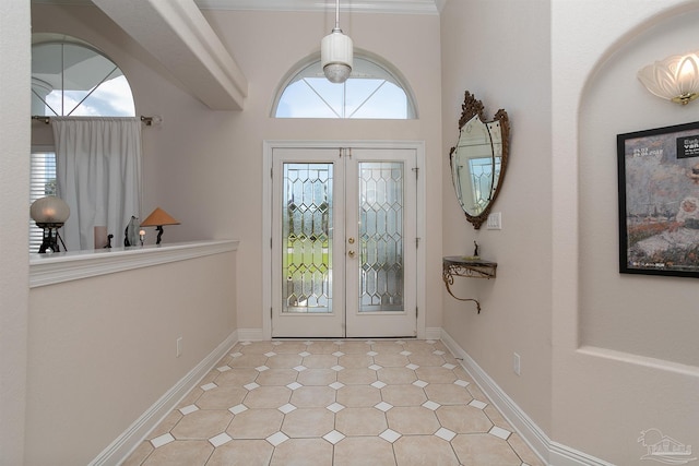 foyer entrance with crown molding and french doors