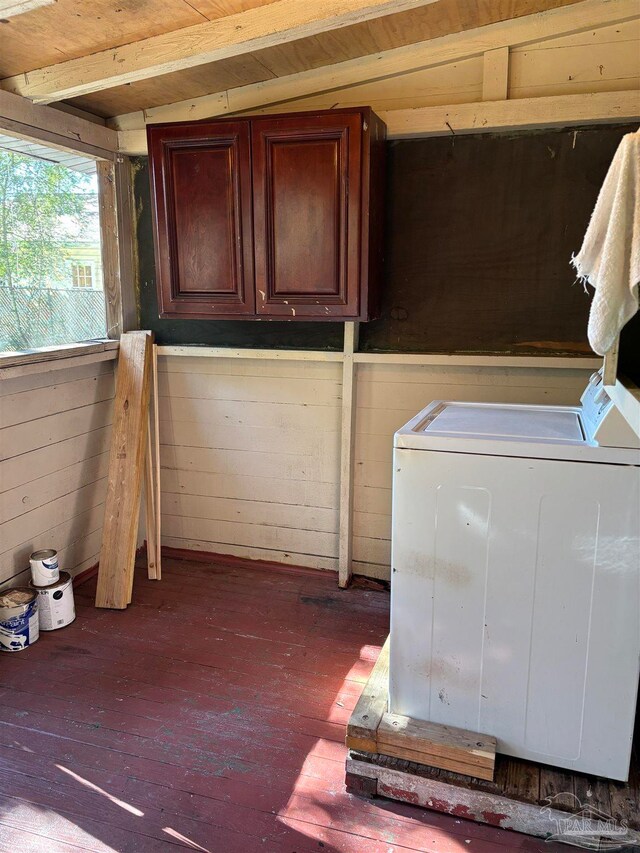 clothes washing area with cabinets and dark wood-type flooring