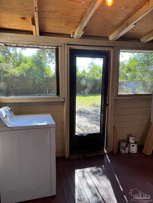 doorway to outside with wooden ceiling, wooden walls, dark hardwood / wood-style floors, beam ceiling, and washer / clothes dryer