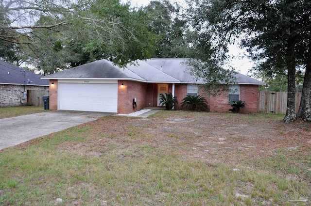 single story home featuring driveway, brick siding, an attached garage, and fence