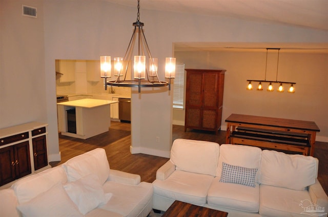 living area featuring a chandelier, dark wood-type flooring, visible vents, and baseboards