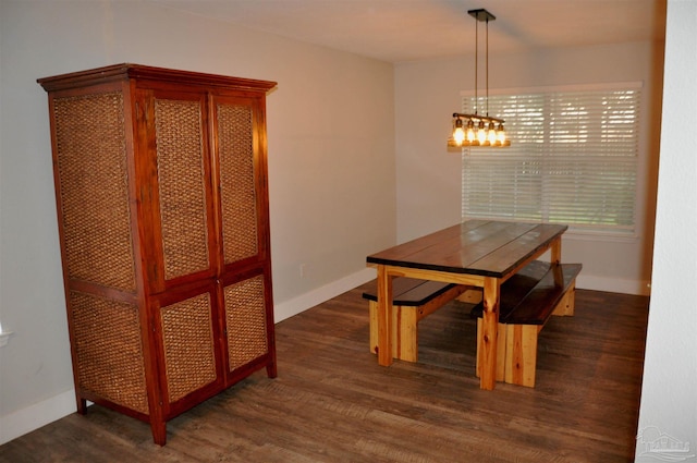 dining space featuring dark wood finished floors and baseboards