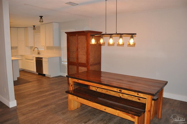 unfurnished dining area featuring sink and dark wood-type flooring