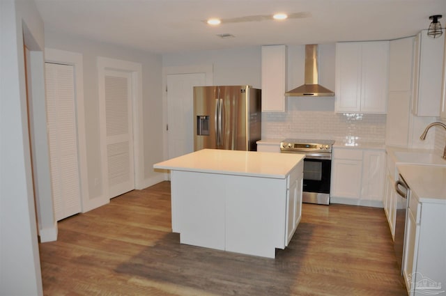 kitchen featuring white cabinetry, sink, wall chimney exhaust hood, light hardwood / wood-style flooring, and appliances with stainless steel finishes