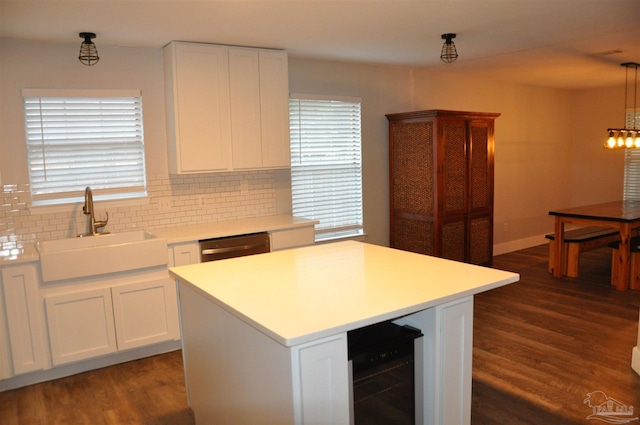 kitchen with beverage cooler, dark wood-type flooring, sink, pendant lighting, and white cabinetry