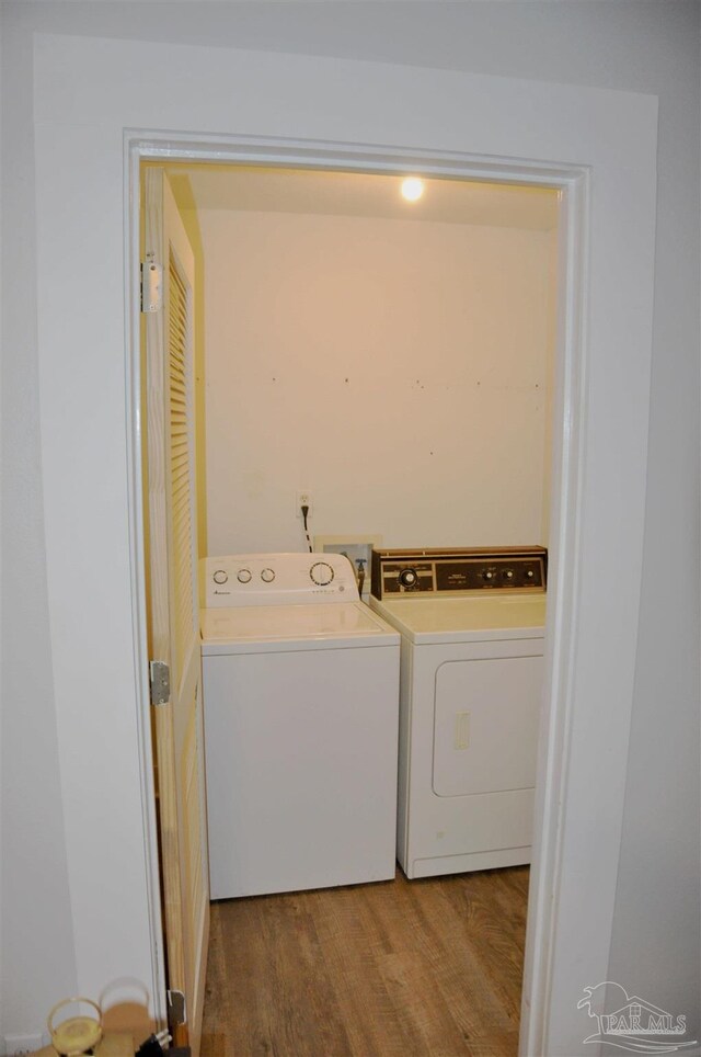 washroom with independent washer and dryer and hardwood / wood-style flooring