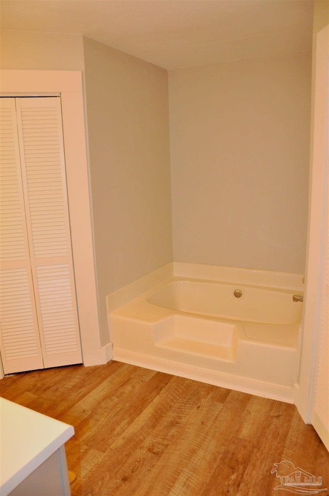 bathroom with vanity, a bath, and hardwood / wood-style flooring