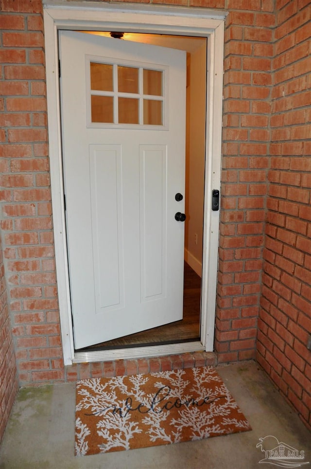 property entrance featuring brick siding