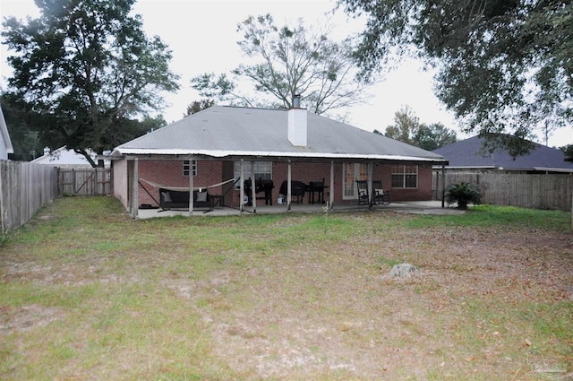 rear view of property with a lawn and a patio area