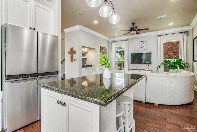 kitchen with white cabinetry, dark hardwood / wood-style floors, stainless steel fridge, and a center island