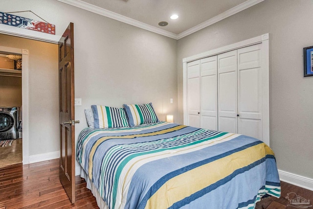 bedroom featuring crown molding, washer and dryer, dark hardwood / wood-style flooring, and a closet