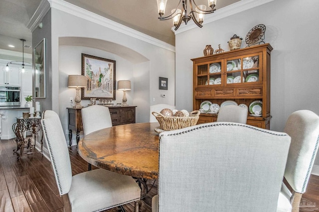 dining room with crown molding, dark hardwood / wood-style floors, and a chandelier