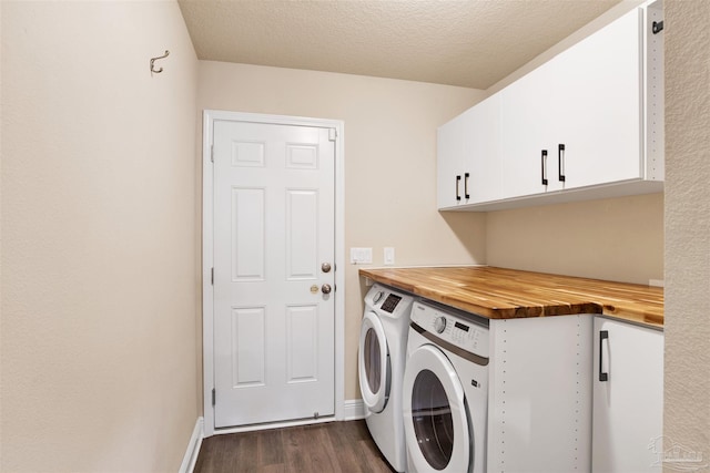 clothes washing area with a textured ceiling, separate washer and dryer, baseboards, cabinet space, and dark wood-style floors