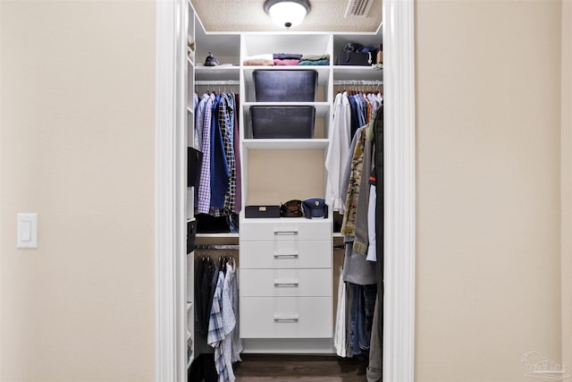 walk in closet featuring dark wood-style flooring and visible vents