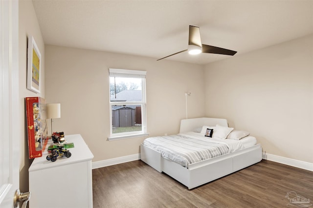 bedroom with ceiling fan, baseboards, and wood finished floors