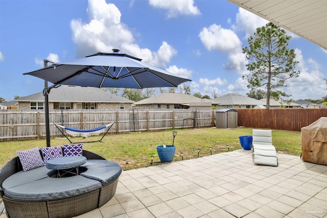 view of patio / terrace with an outbuilding, a fenced backyard, and a storage shed