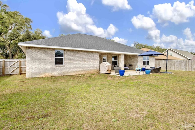 rear view of house with a patio, a fenced backyard, brick siding, a shingled roof, and a yard