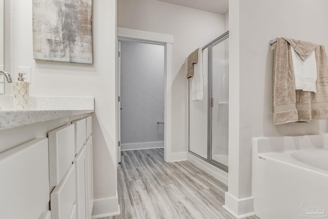 9777 Windy Hill Rd, Pensacola, FL 32526 - full bath with a stall shower, vanity, a garden tub, and wood finished floors