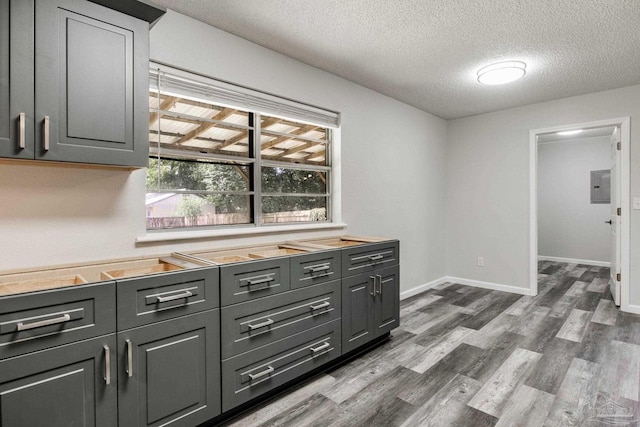 7125 Ben Sasser Dr, Pensacola, FL 32526 - kitchen featuring electric panel, dark wood finished floors, a textured ceiling, and light countertops