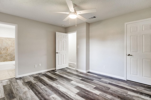 7125 Ben Sasser Dr, Pensacola, FL 32526 - unfurnished bedroom with wood finished floors, a textured ceiling, ensuite bath, and ceiling fan