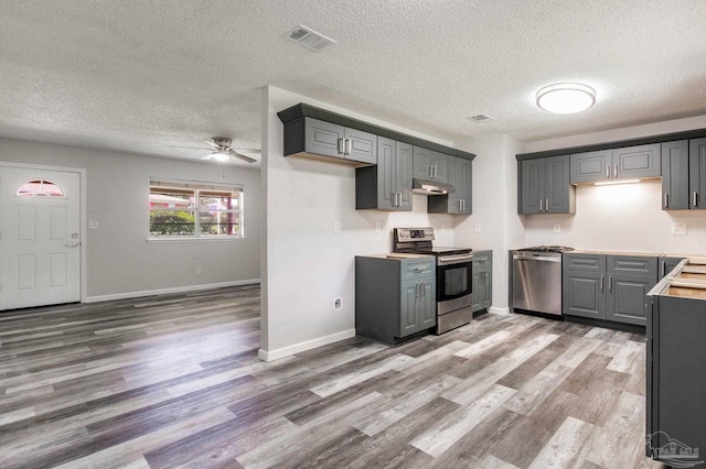 7125 Ben Sasser Dr, Pensacola, FL 32526 - kitchen with appliances with stainless steel finishes, ceiling fan, wood finished floors, a textured ceiling, and gray cabinetry