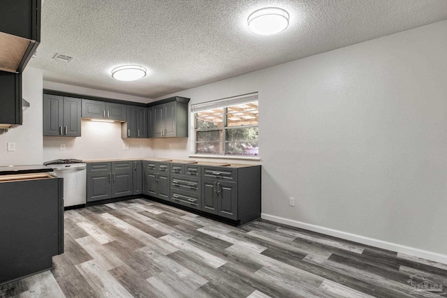 7125 Ben Sasser Dr, Pensacola, FL 32526 - kitchen featuring gray cabinets, stainless steel dishwasher, wood finished floors, and a textured ceiling