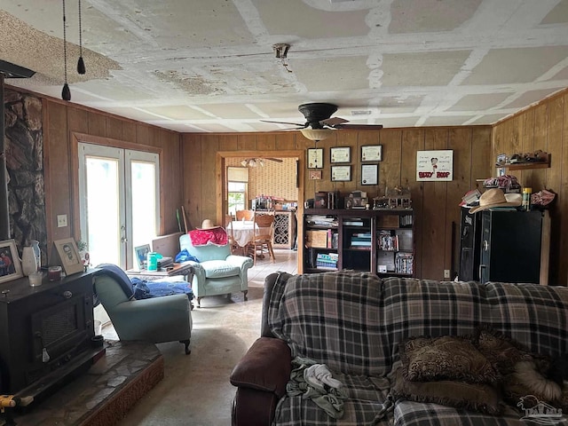2939 Sundance Ln, Cantonment, FL 32533 - living area featuring wooden walls, a wood stove, ceiling fan, and french doors