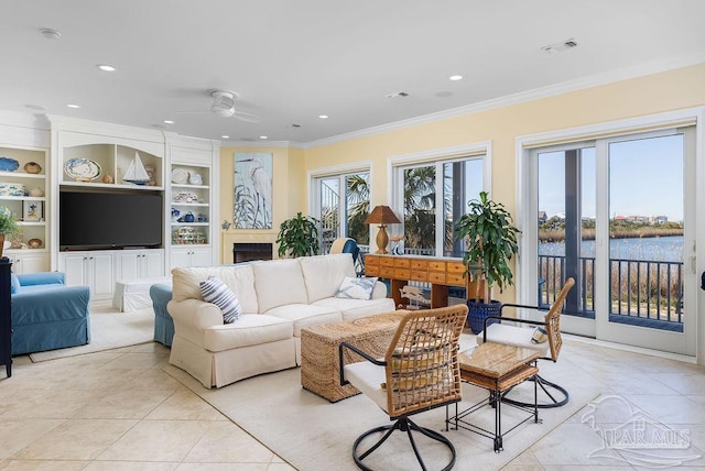 tiled living room with ornamental molding, a wealth of natural light, built in features, and a water view