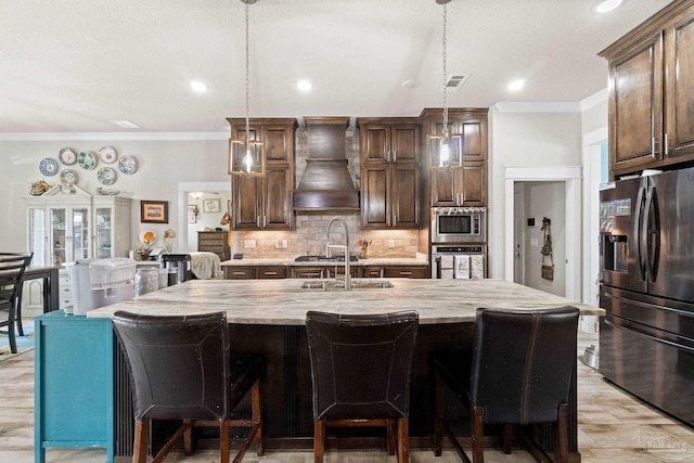 2420 Okatie Ln, Cantonment, FL 32533 - kitchen with stainless steel appliances, a sink, premium range hood, crown molding, and tasteful backsplash