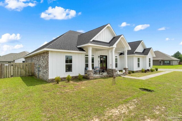 2420 Okatie Ln, Cantonment, FL 32533 - modern farmhouse style home featuring board and batten siding, a shingled roof, a front yard, and fence