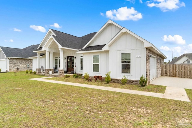2420 Okatie Ln, Cantonment, FL 32533 - view of front of home with board and batten siding, a shingled roof, covered porch, an attached garage, and a front yard
