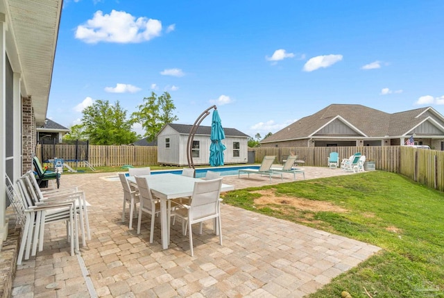 2420 Okatie Ln, Cantonment, FL 32533 - view of patio featuring a fenced backyard, an outdoor structure, a storage unit, and outdoor dining space