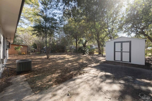 view of yard with central air condition unit, a shed, and a patio