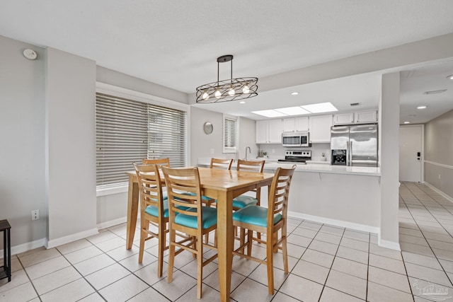 dining area featuring light tile patterned floors, recessed lighting, and baseboards