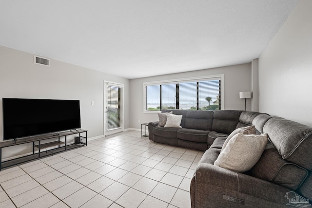 living area featuring light tile patterned flooring and baseboards